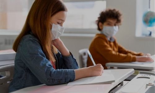 Masked students working in class