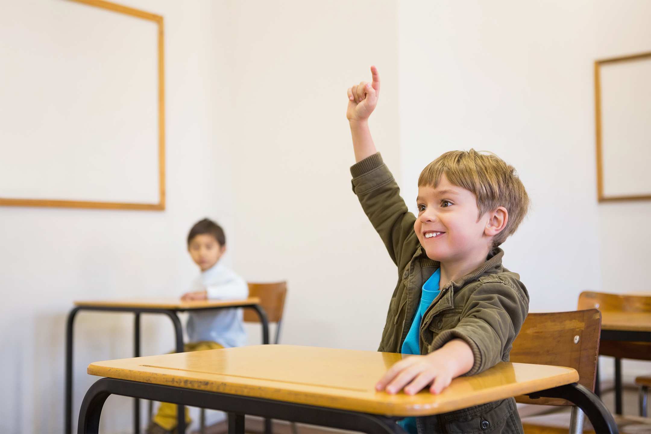 confident boy raising hand in class